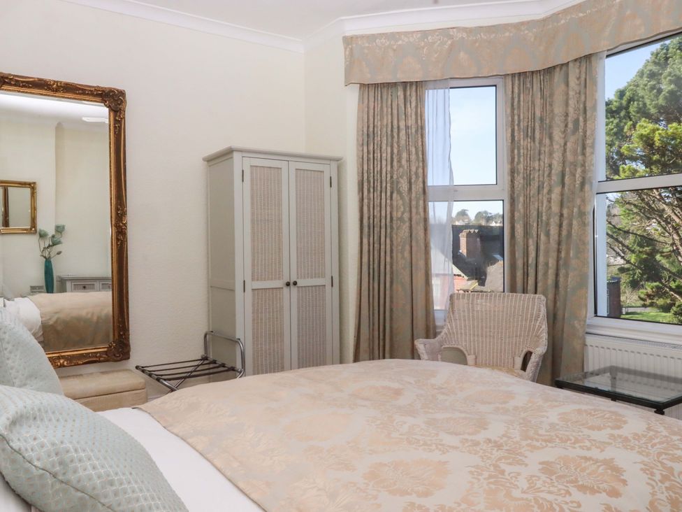 A bedroom with a bed and mirror at Avenue Park Villa in Torquay