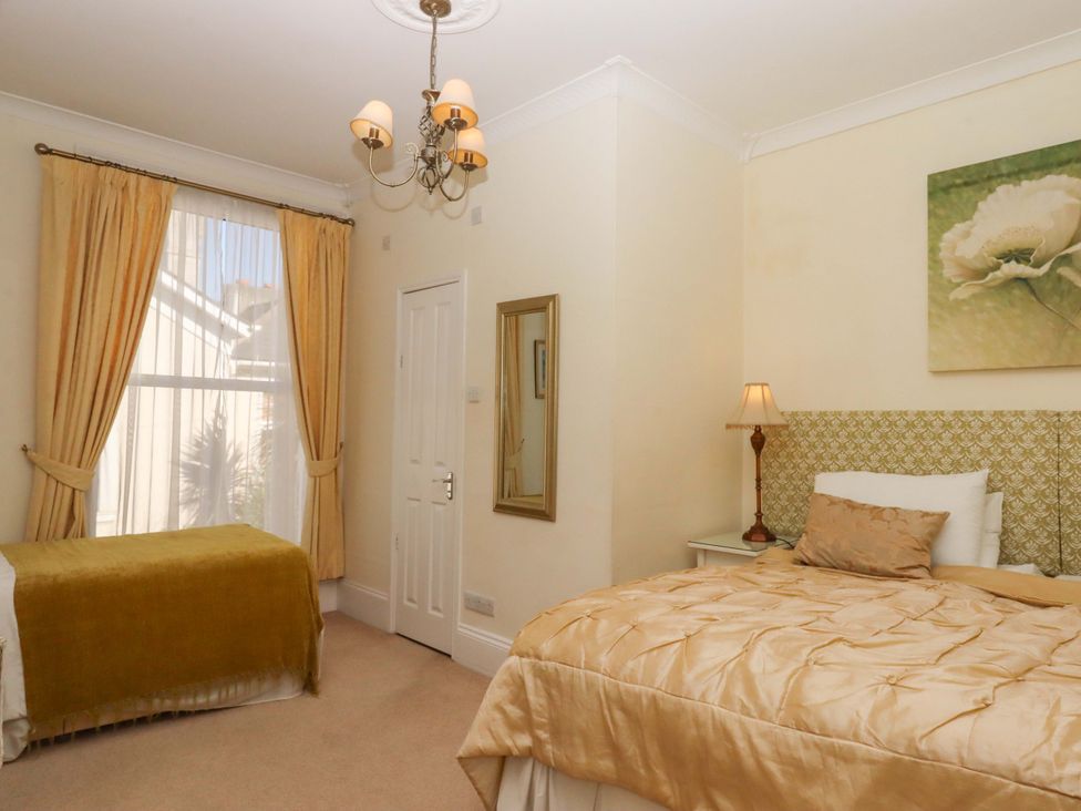 A bedroom with two beds and a mirror at Avenue Park Villa in Torquay