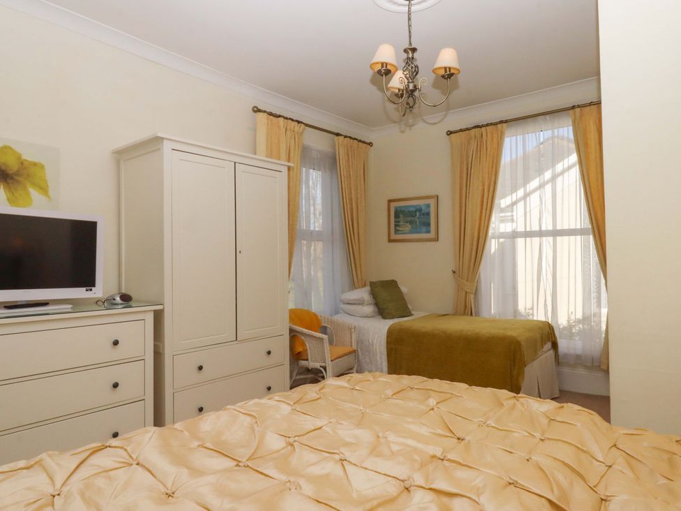 A bedroom with a bed and wardrobe at Avenue Park Villa in Torquay