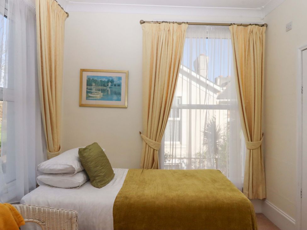 A bedroom with a bed and painting at Avenue Park Villa in Torquay