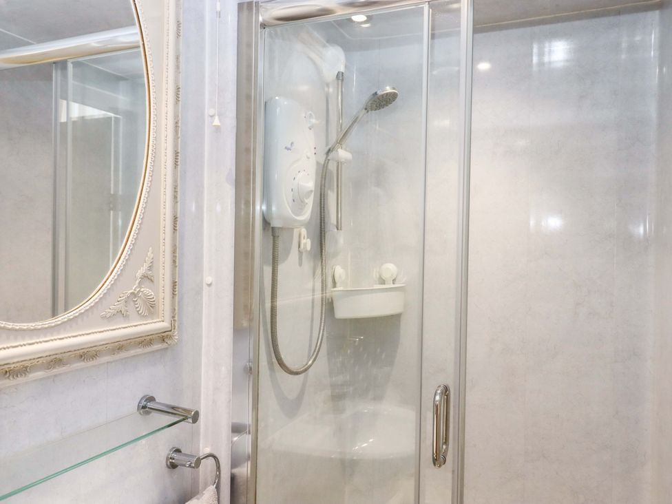 A bathroom with a shower and mirror at Avenue Park Villa in Torquay