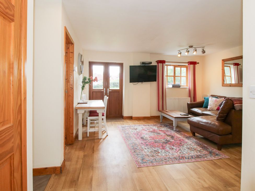 A living room with a sofa and table at Old Hall Barn 1 in Church Stretton