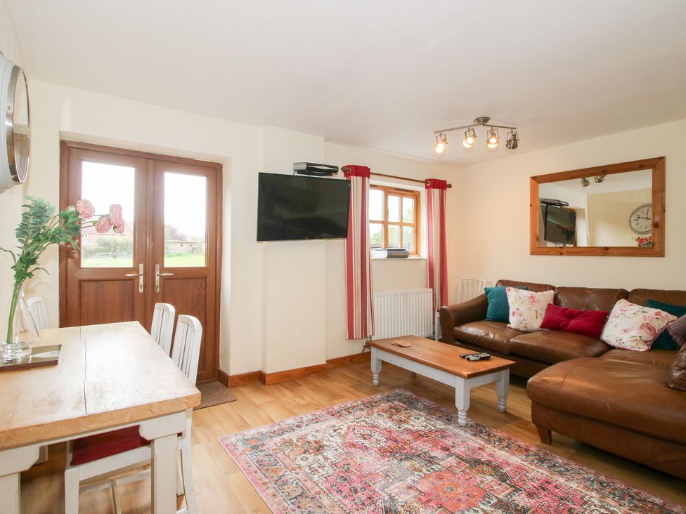 A living room with a table and sofa at Old Hall Barn 1 Church Stretton