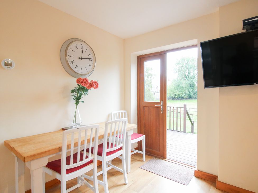 A dining room with a table and chairs at Old Hall Barn 1 Church Stretton