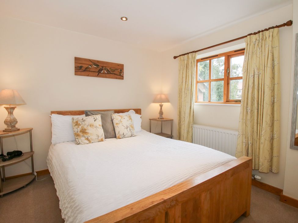 A bedroom with a bed and bedside table at Old Hall Barn 1 Church Stretton