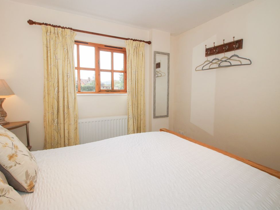 A bedroom with a bed and window at Old Hall Barn 1 Church Stretton