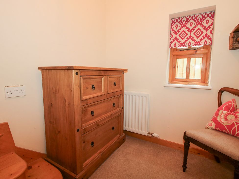 A bedroom with a dresser and a window at Old Hall Barn 1 Church Stretton