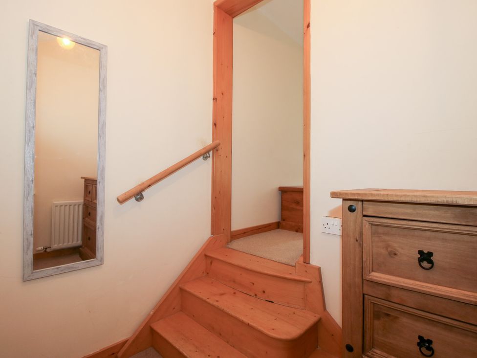 A staircase with a handrail and mirror in a hallway at Old Hall Barn 1, Church Stretton