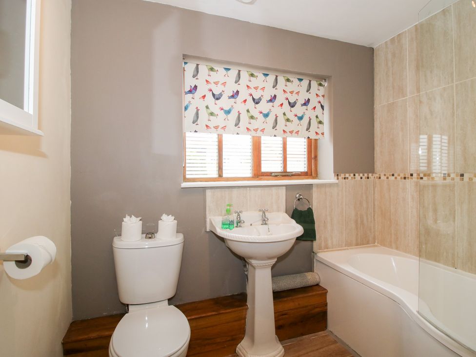 A bathroom with a toilet, sink, and bathtub at Old Hall Barn 1, Church Stretton