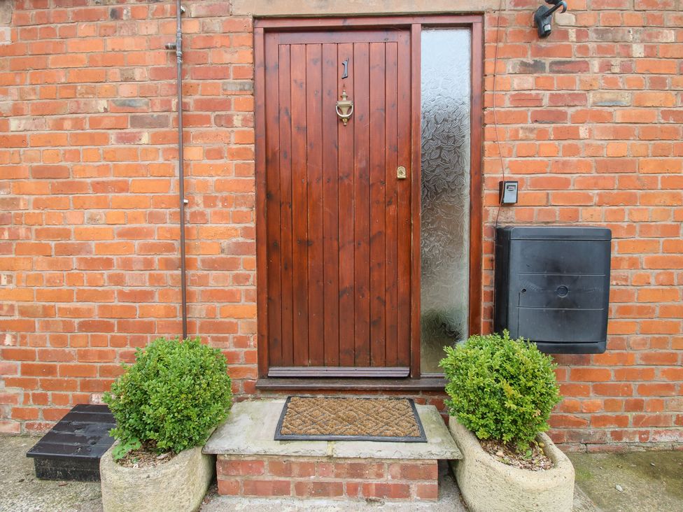 A front entrance with a wooden door and a mailbox at Old Hall Barn 1 Church Stretton