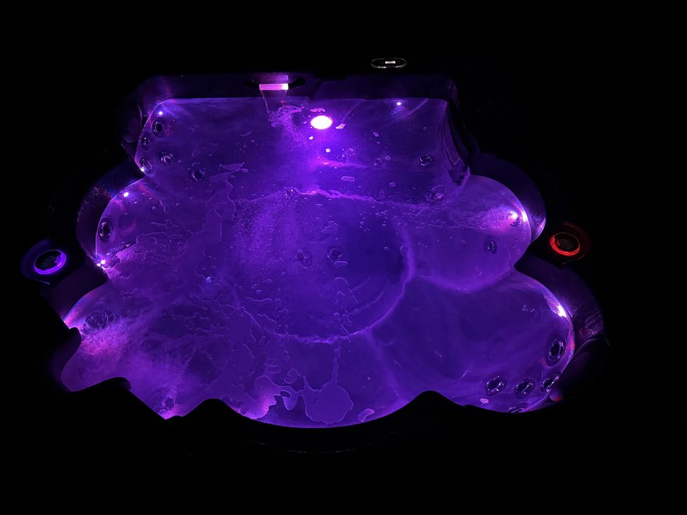A hot tub with bubbles and colored lights at Willow Lodge in Constantine near Falmouth