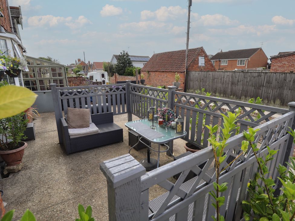 A garden with seating and a table at 1 The Bays Burgh Le Marsh