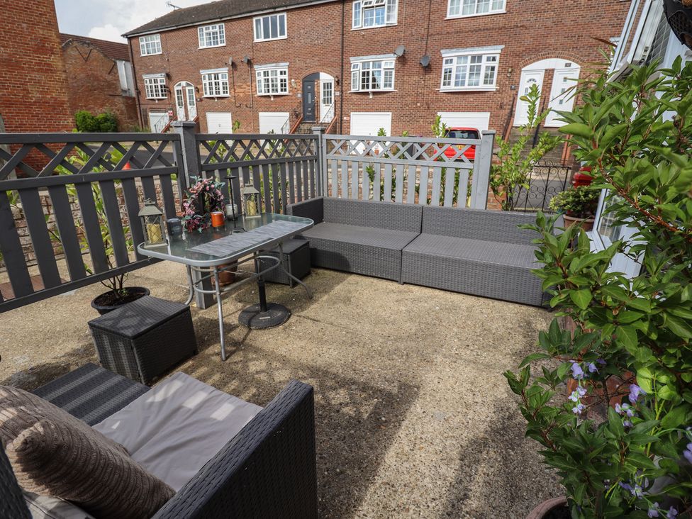 A garden with a table and seating area at 1 The Bays Burgh Le Marsh