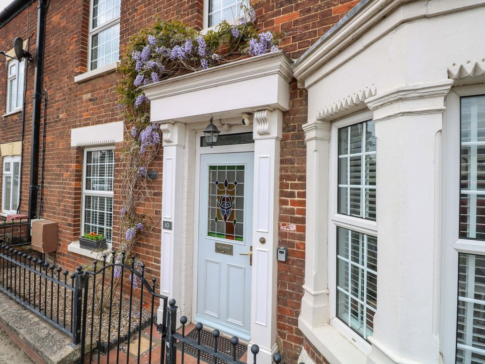 A front door with a window and flowers at Springfield in Hempton near Fakenham