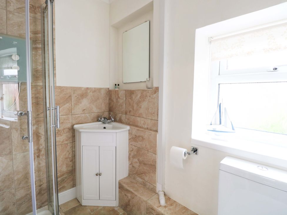 A bathroom with a shower, sink, and toilet at Springfield in Hempton near Fakenham