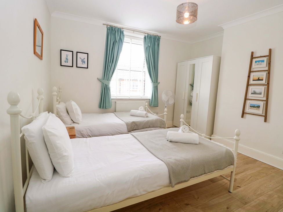 A bedroom with two beds and a wardrobe at Springfield in Hempton near Fakenham