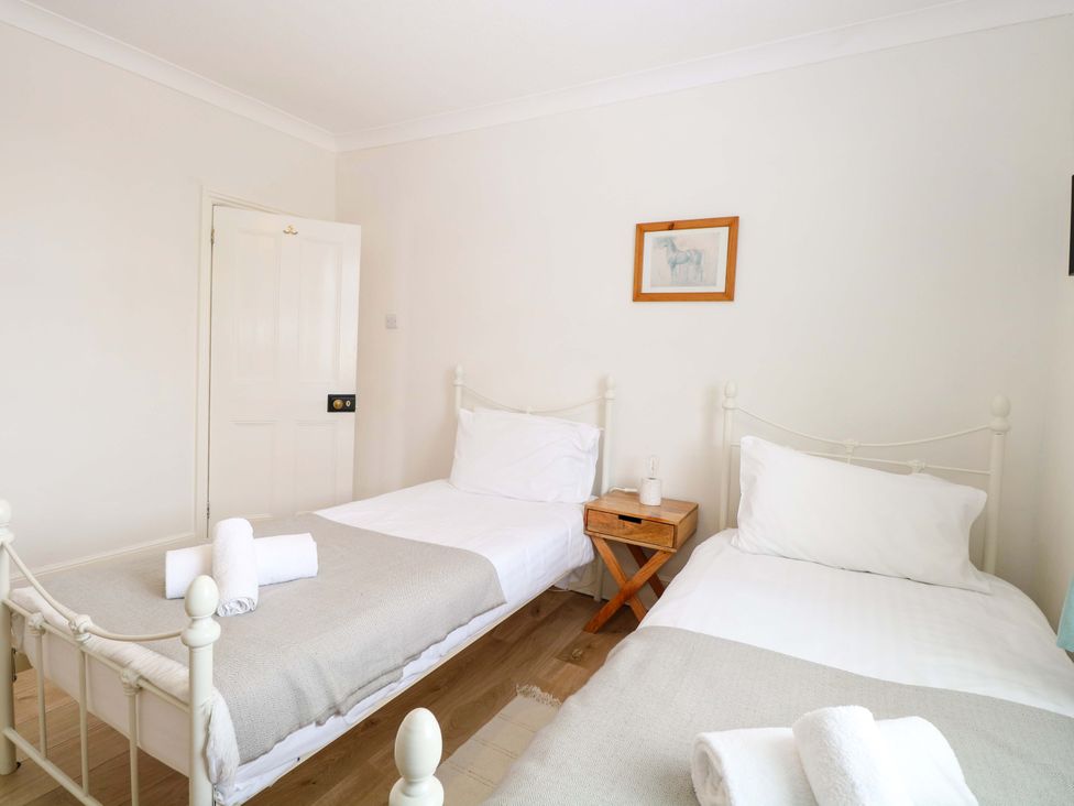 A bedroom with two single beds and a bedside table at Springfield in Hempton near Fakenham