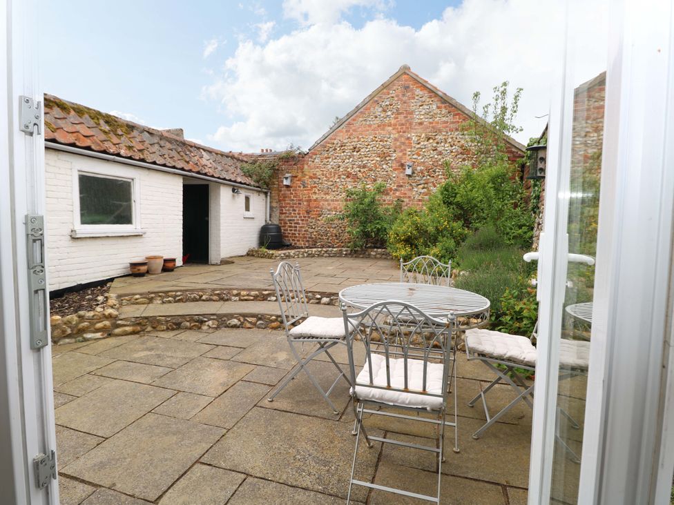 A patio with a table and chairs at Springfield in Hempton near Fakenham