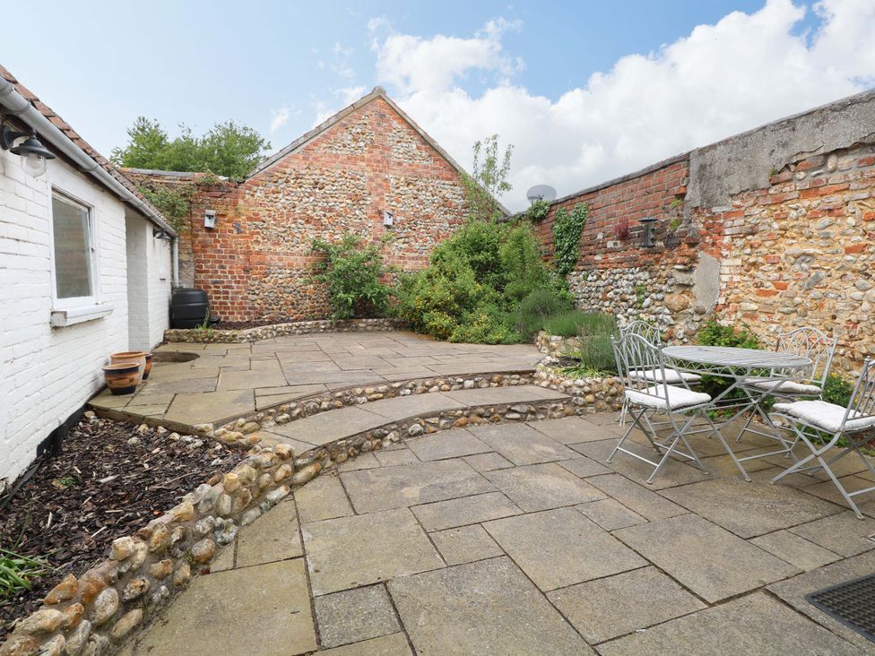 A garden with a patio and seating area at Springfield in Hempton near Fakenham
