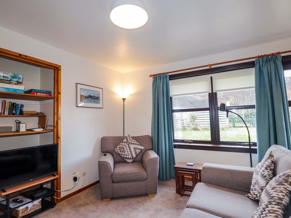 A living room with a sofa and armchair at Church House in Poolewe