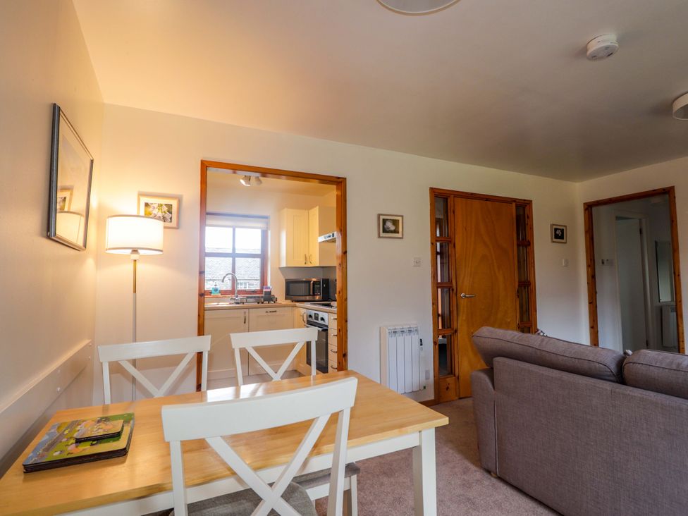 A living room with a table and chairs at Church House in Poolewe