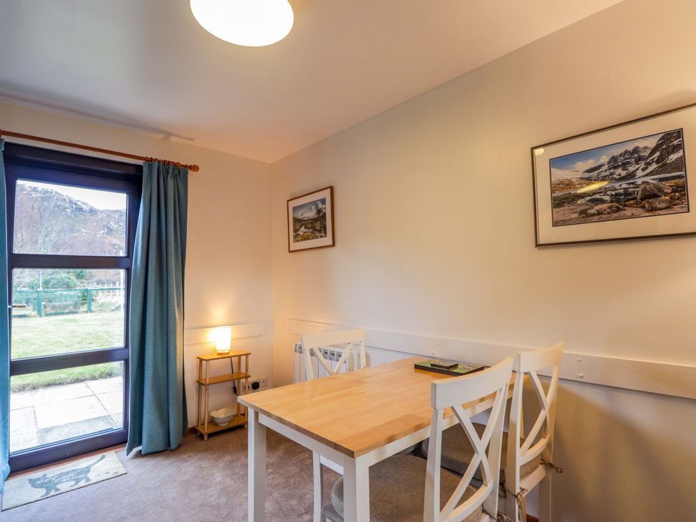A dining room with a table and chairs at Church House in Poolewe