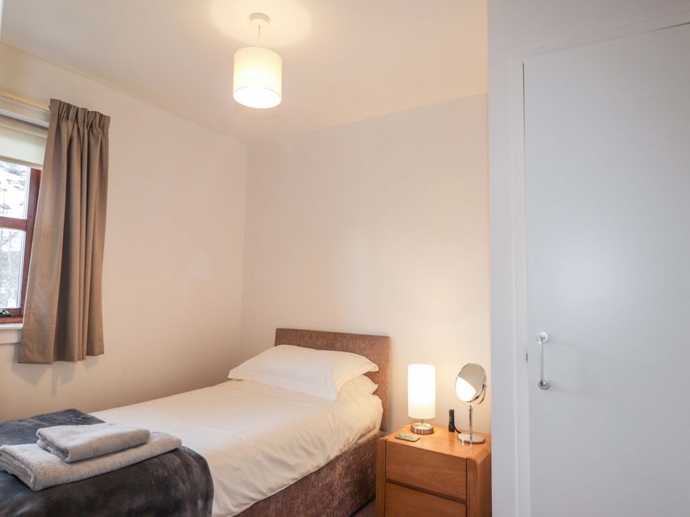 A bedroom with a bed and nightstand at Church House in Poolewe