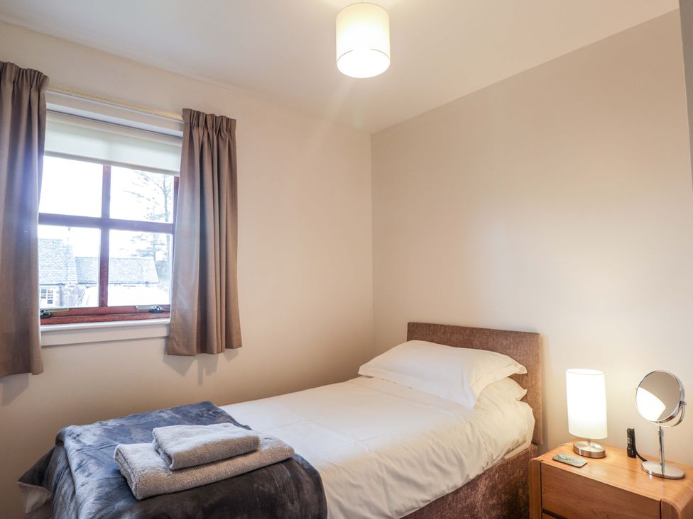 A bedroom with a bed and a window at Church House Poolewe