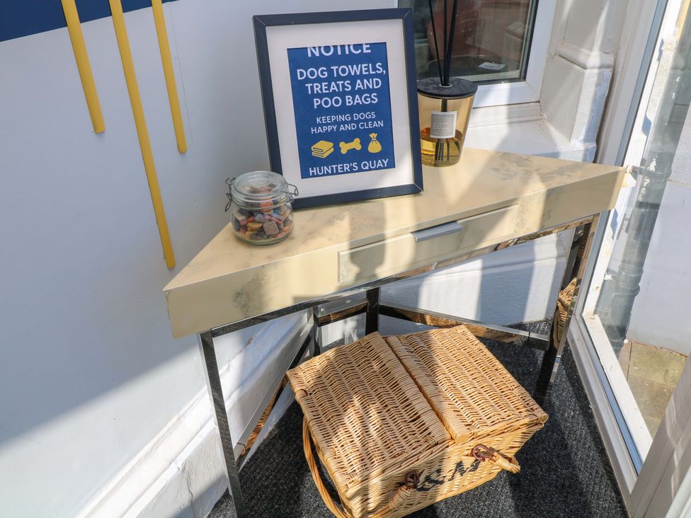 An entryway table with a notice frame, a jar, and a basket at Apt 5 @ Hunter's Quay in Bridlington