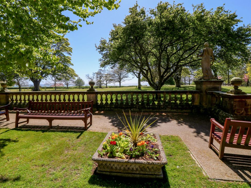 A garden with benches and a flower bed at Apt 5 @ Hunter's Quay, Bridlington
