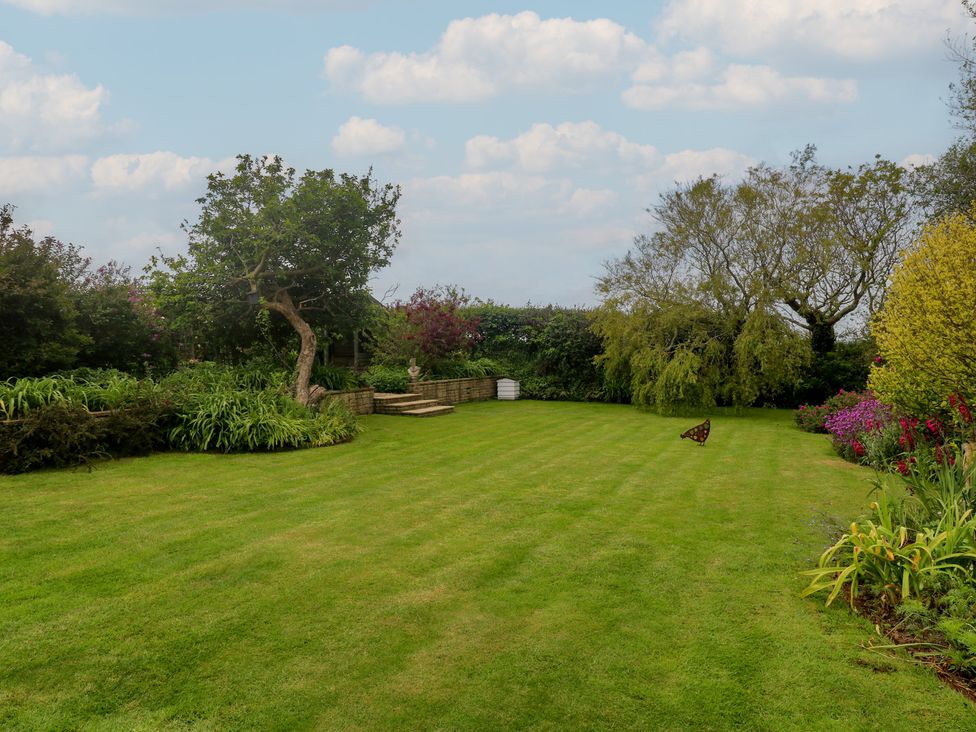 A garden with grass and trees at Woolly Welcome in Goldsithney