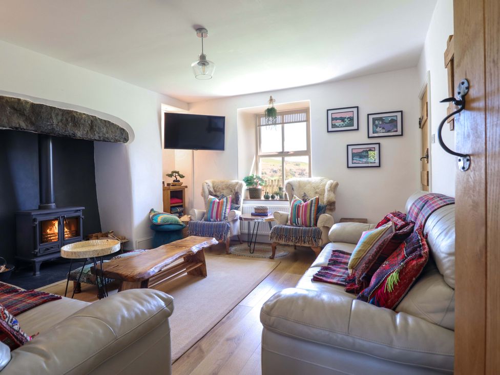 A living room with a fireplace and seating area at Cefn Nannau near Ty-nant Cerrigydrudion