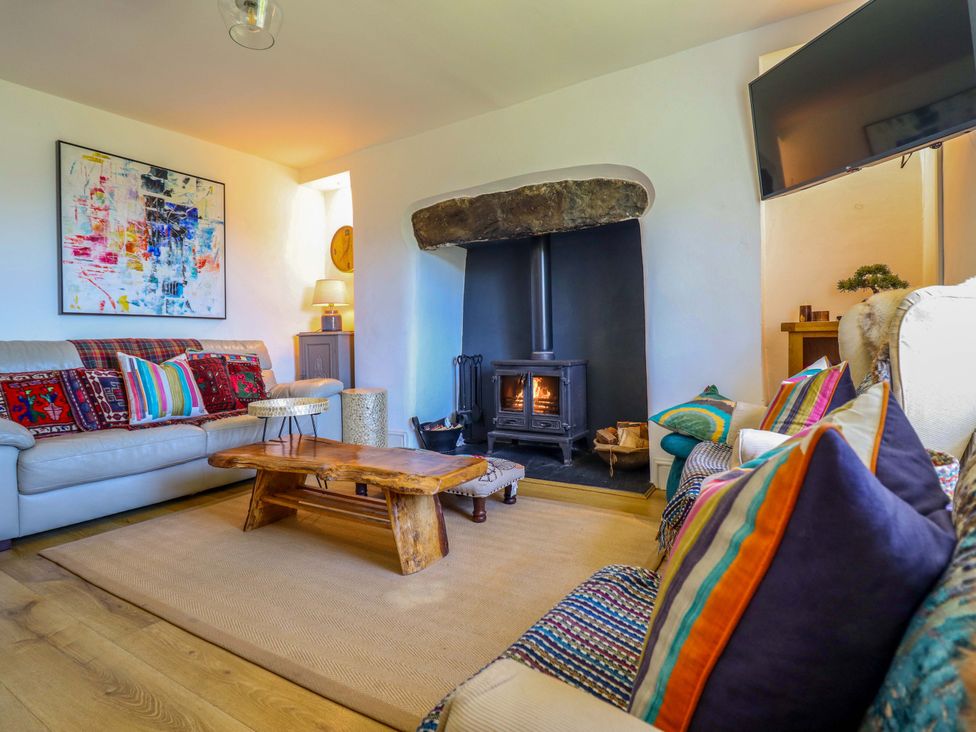 A living room with a stove and sofa at Cefn Nannau near Ty-nant Cerrigydrudion