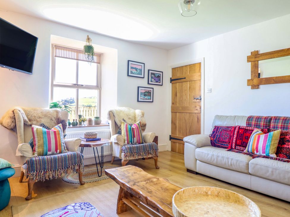 A living room with chairs and a television at Cefn Nannau Ty-nant near Cerrigydrudion