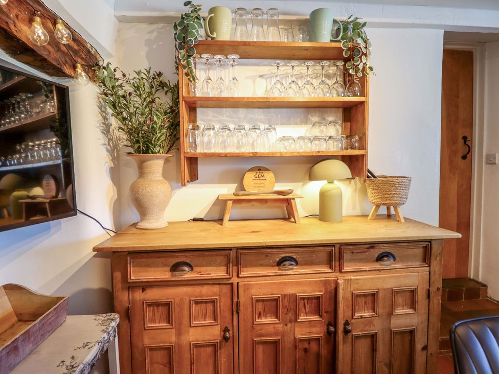 A wooden cabinet with glassware and a vase at Cefn Nannau Ty-nant near Cerrigydrudion