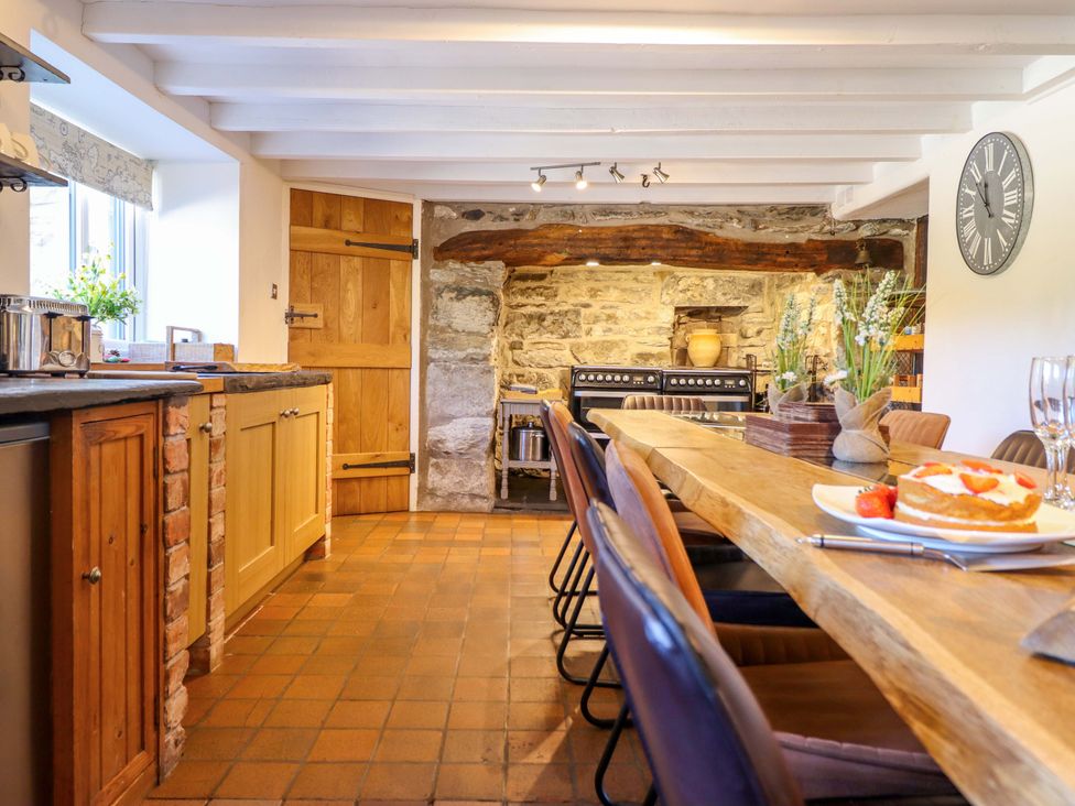 A kitchen with a dining table and an oven at Cefn Nannau Ty-nant near Cerrigydrudion