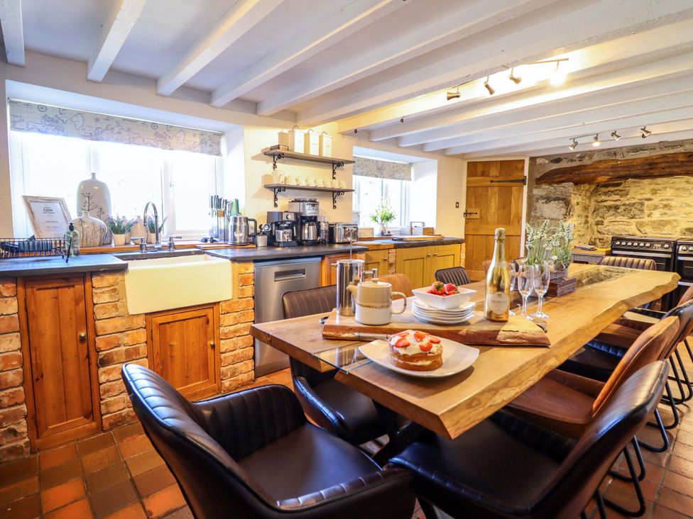 A kitchen with a large table and various kitchen appliances at Cefn Nannau Ty-nant near Cerrigydrudion