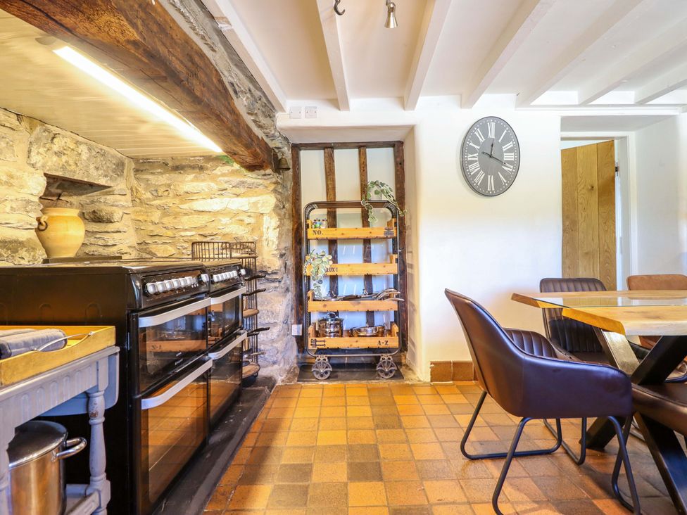 A kitchen featuring an oven, sink, and wooden shelf at Cefn Nannau Ty-nant near Cerrigydrudion