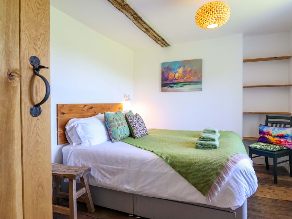 A bedroom with a bed and wooden shelf at Cefn Nannau near Ty-nant Cerrigydrudion