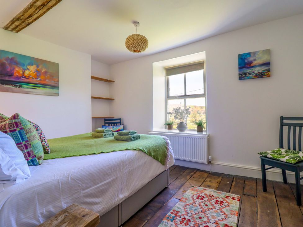 A bedroom with a bed and chair at Cefn Nannau near Ty-nant near Cerrigydrudion