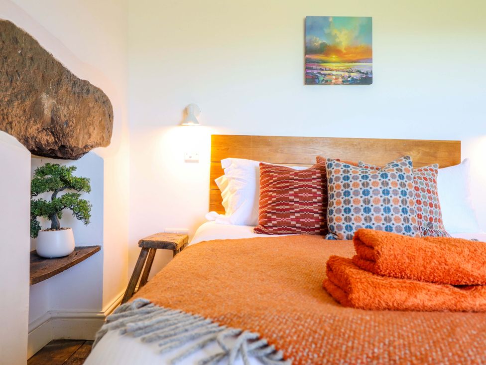 A bedroom with a bed, pillows, towels, and a plant at Cefn Nannau Ty-nant near Cerrigydrudion
