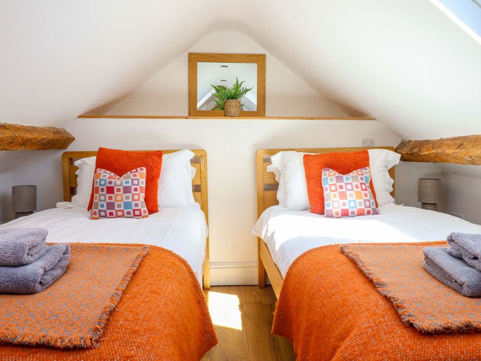 A bedroom with two beds and a mirror shelf at Cefn Nannau Ty-nant near Cerrigydrudion