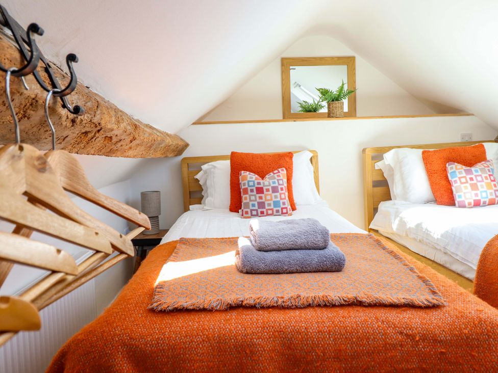 A bedroom with twin beds and a mirror at Cefn Nannau Ty-nant near Cerrigydrudion