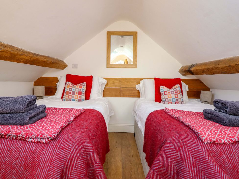 A bedroom with two single beds and a mirror at Cefn Nannau in Ty-nant near Cerrigydrudion