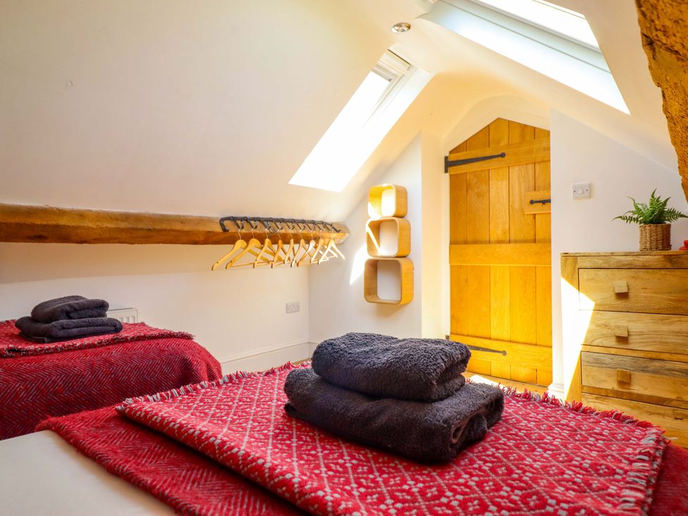 A bedroom with towels on beds and a wooden door at Cefn Nannau Ty-nant near Cerrigydrudion