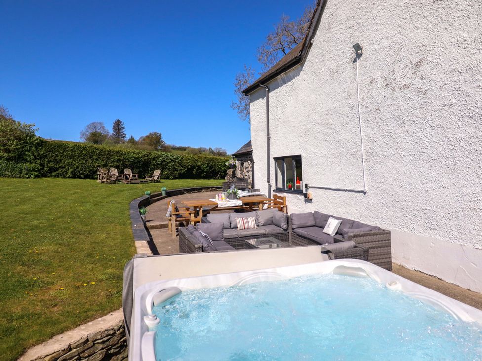 A garden area with a hot tub and outdoor seating at Cefn Nannau Ty-nant near Cerrigydrudion