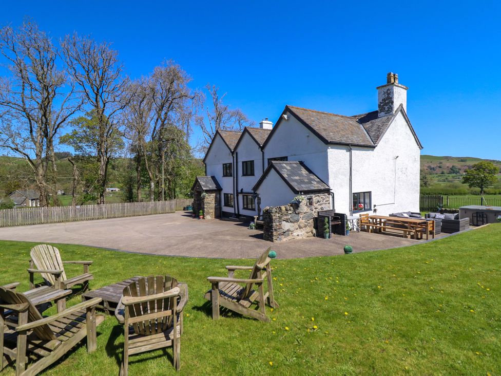 An outdoor area with a house and chairs at Cefn Nannau Ty-nant near Cerrigydrudion