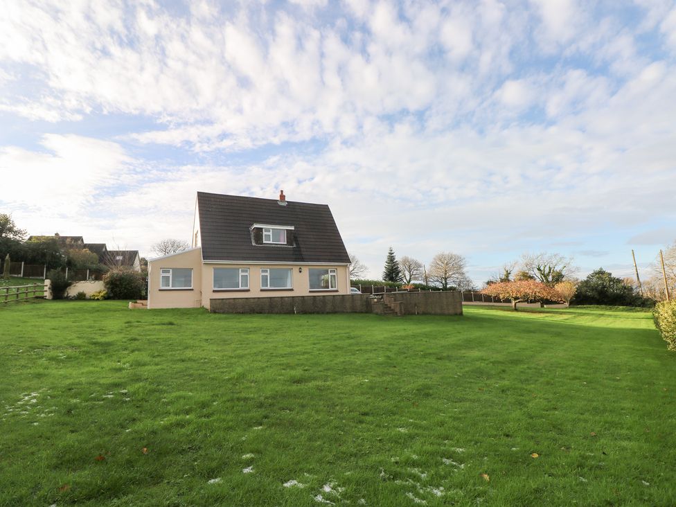 A house with a large lawn and trees at Cherry Trees Haverfordwest