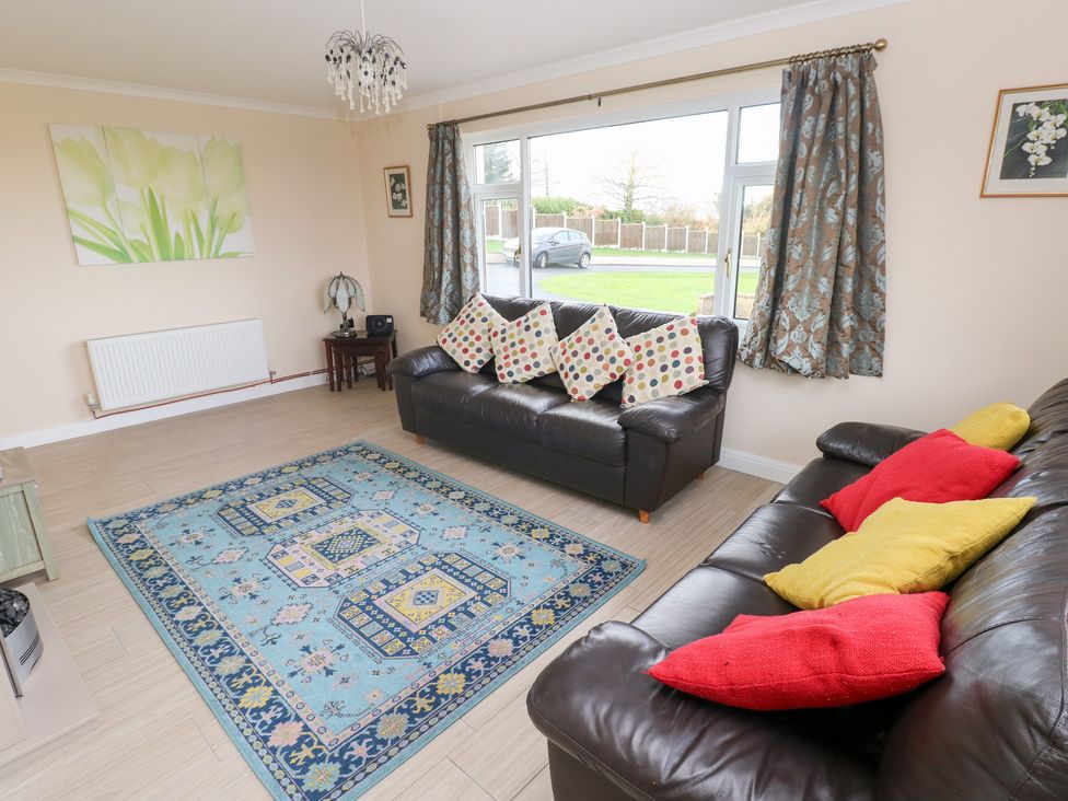 A living room with sofas and a rug at Cherry Trees Haverfordwest