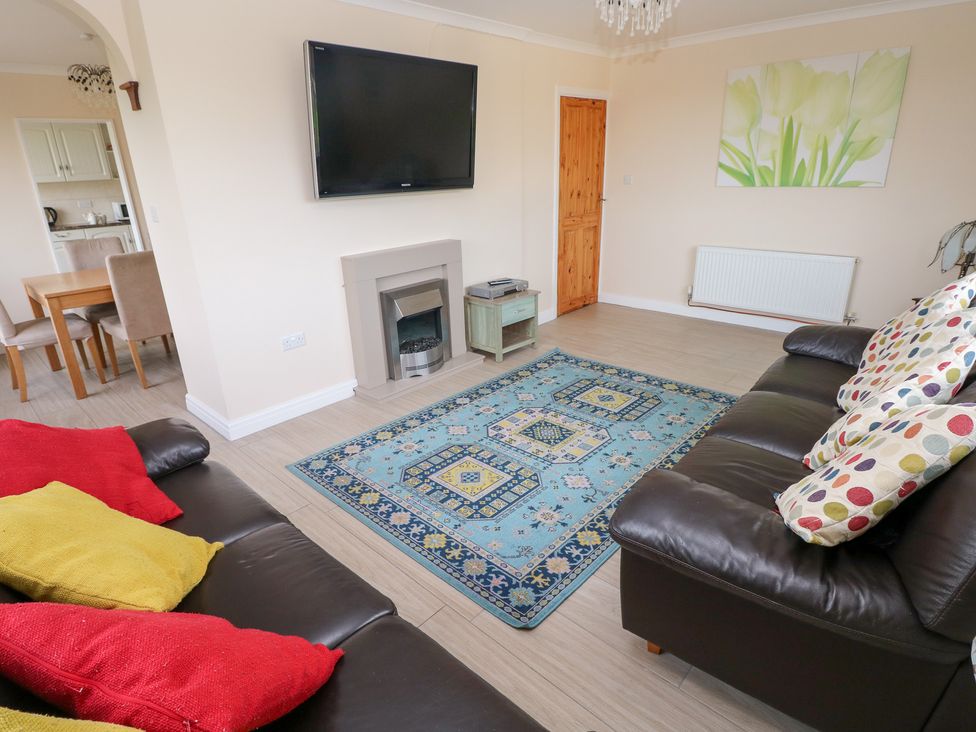 A living room with a television and sofa at Cherry Trees in Haverfordwest